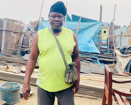 ‘They told us to leave. They didn’t tell us where to go’: the demolitions destroying homes and lives in Lagos A man standing in front of his destroyed home. Blue plastic sheets are wrapped around broken wooden structures.