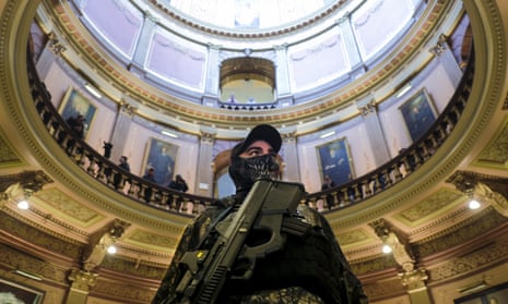 An armed protester stands at the Michigan capitol building in Lansing, Michigan, on 30 April.