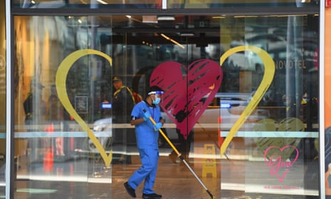 A person cleans the entrance of the Novotel Melbourne South Wharf hotel on Wednesday. Floor managers employed by contractor Spotless have been stood down and replaced by Victoria police after people working at the hotel contracted Covid-19. 