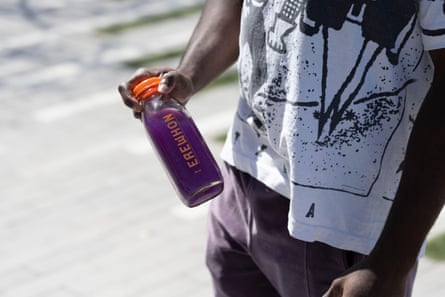hand holds purple smoothie in bottle