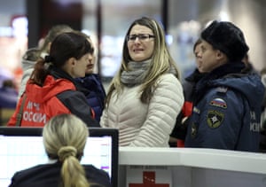 A woman reacts next to Russian Emergencies Ministry members at Pulkovo airport in St. Petersburg