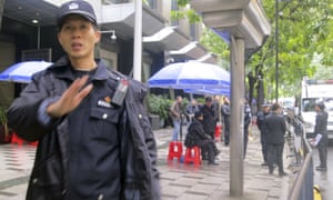 Policemen stand guard outside a court in the southern Chinese city of Guangzhou on Friday where three civil rights activists were sentenced.