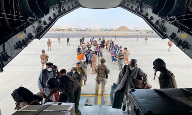 Afghans board a military plane at the Hamid Karzai International Airport, Kabul.