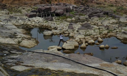 An Indian villager walks between rocks as he crosses a depleted reservoir in Tikamgarh in the central Indian state of Madhya Pradesh.