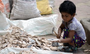 An Indian child breaks apart broken tiles outside an under-construction apartment building in Mumbai.