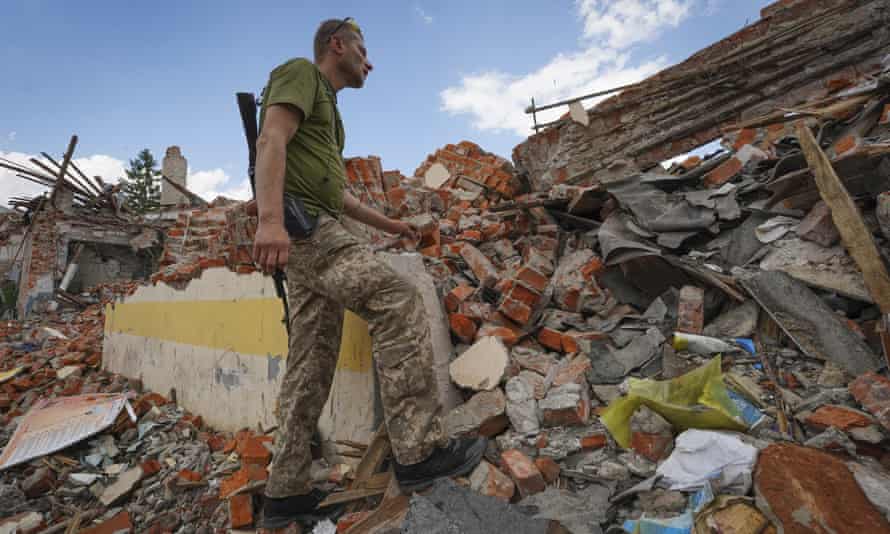 A Ukrainian serviceman looks at the rubble of a school that was destroyed some days ago during a missile strike in the outskirts of Kharkiv.