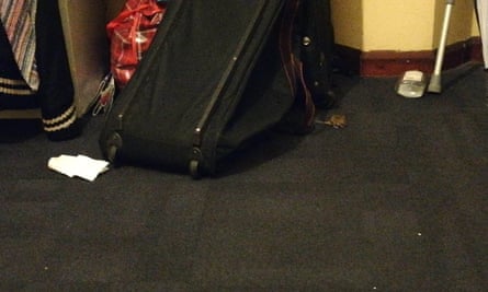 Grainy closeup of a mouse running out from under a bag on a dirty floor