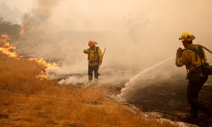 Firefighters work a hot spot caused by the Woosley fire in Malibu, California on Saturday.