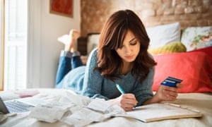 woman planning purchases on bed