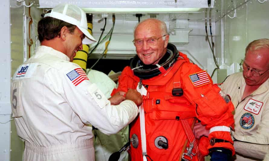 John Glenn getting a hand from white room technicians moments before boarding the US space shuttle Discovery.