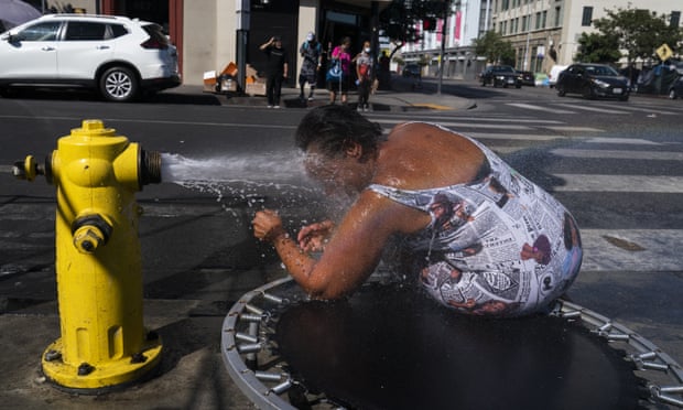 A man cools off with water from a fire hydrant in Los Angeles.
