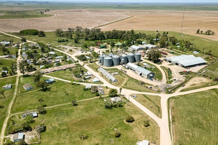 Aerial view of a grains stores reached by access roads, surrounded by agricultural fields.