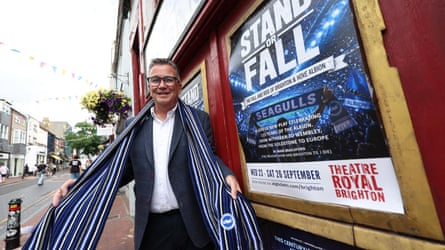 Ian Hart, with a Brighton scarf next to a poster for Stand or Fall outside BrightonâÂÂs Theatre Royal.