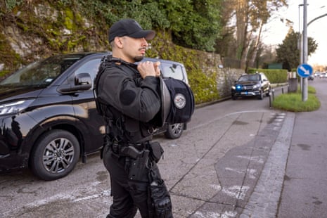 Police officers standing on a road as cars drive past behind them.