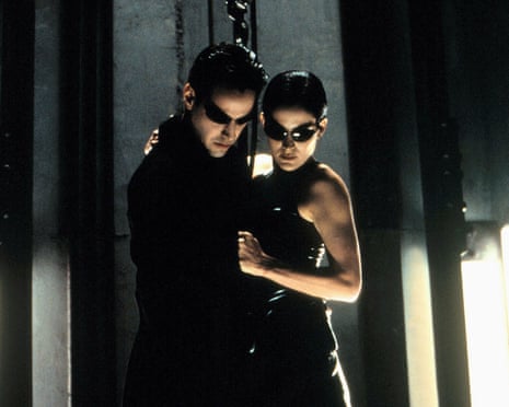 film still of man and a woman dressed in black wearing sunglasses looking down