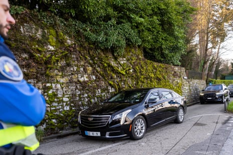 A car carrying the US delegation driving past officers.