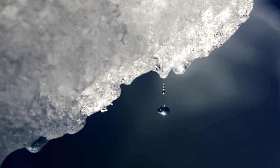 A drop of water falls off an iceberg melting in the Nuup Kangerlua Fjord in south-west Greenland