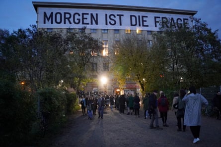 Visitors stand in a queue in front of Berghain in the evening