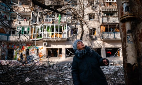 A woman in front of a building damaged by Russian shelling in Kherson.
