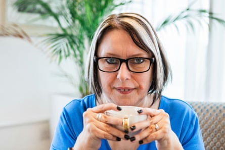 Veronica Pullen sits holding a cup of tea