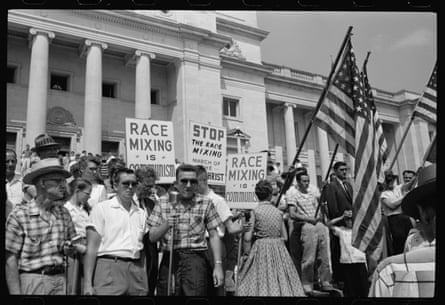 White demonstrators holding US flags and racist placards.