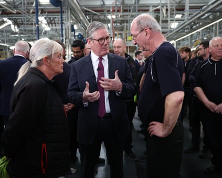 British prime minister Keir Starmer talks with car workers inside a car plant