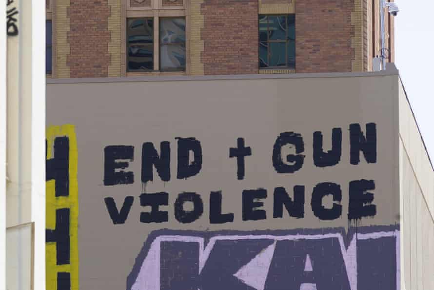 A sign painted on the side of a building reads ‘End gun violence’.