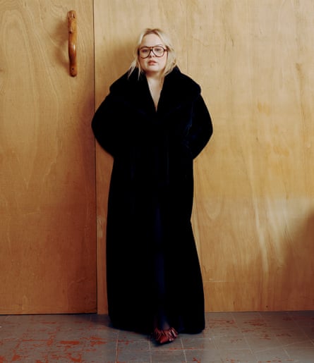 Actor Nicola Coughlan wearing a long black coat and glasses