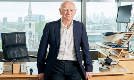 Howard Davies pictured stood leaning back against his office desk