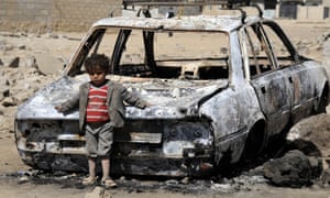 A Yemeni child leans on the wreckage of car after airstrikes by Saudi Arabia on Sana’a, Yemen.