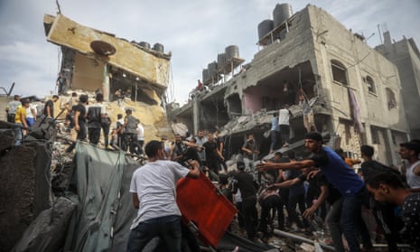 People search for victims amid the rubble of houses hit by Israeli bombing in Rafah, in the southern Gaza Strip, on 11 November.
