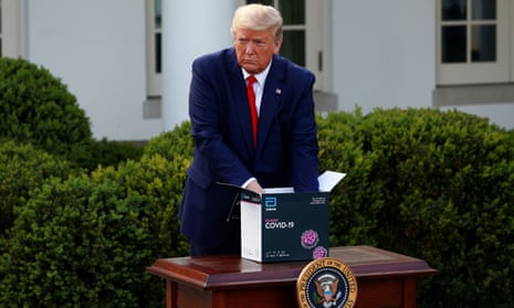 Donald Trump with a coronavirus test kit at a White House briefing, 30 March 2020