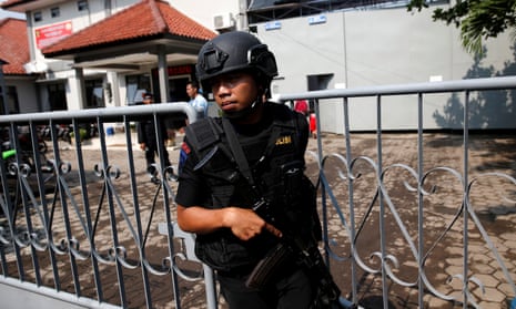 An armed police officer at the gate to the ferry port for the prison island of Nusa Kambangan in Cilacap, Indonesia.