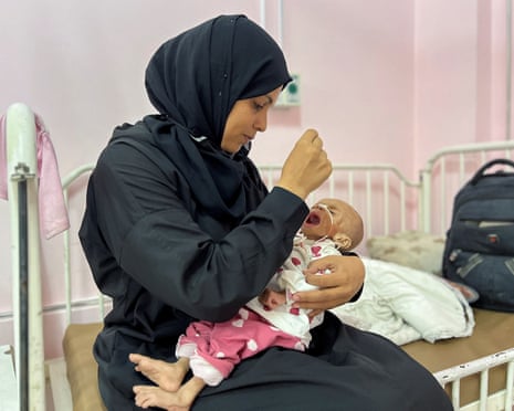Palestinian mother Israa Abu Haleeb looks after her five-month-old daughter, Zainab, who is diagnosed with malnutrition, according to medics, at Nasser hospital in Khan Younis, in the southern Gaza Strip on 15 July 2025.