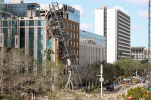 a collapsed crane leans on a damaged building