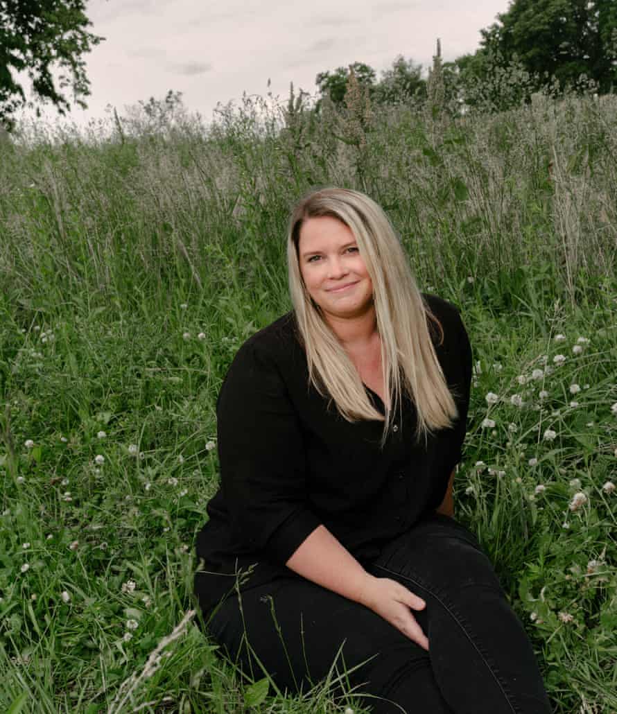 Kate Baer dressed in black sitting in a field