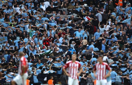 Stoke City players stand dejected as the Manchester City fans do the Poznan celebration