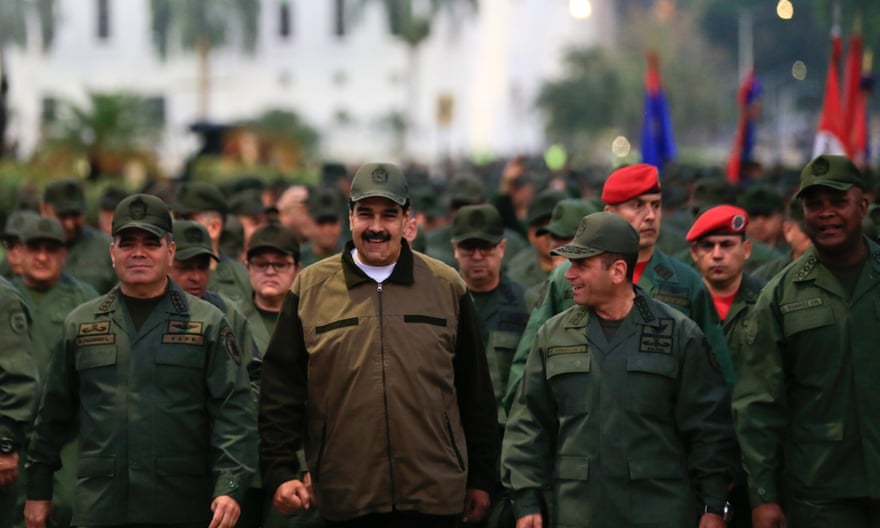 Venezuela’s President Nicolás Maduro is accompanied by the defence minister, Vladimir Padrino, left, and a large body of loyal troops in Caracas on Thursday.