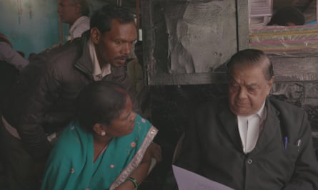 A man and a woman look at another man who is holding a piece of paper.