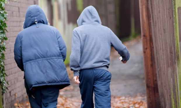 Two teenage boys in hoodies walking together