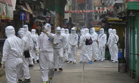 Government investigators wearing protective suits gather in the Yau Ma Tei area in Hong Kong, where thousands of residents have been locked down