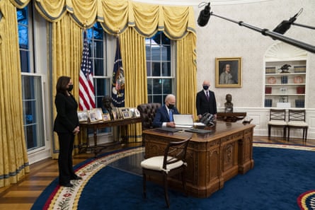 Vice-President Kamala Harris, left, and Alejandro Mayorkas, the homeland security secretary, look on as President Joe Biden signs an executive order on immigration.