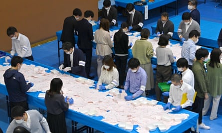Officials of the election administration committee count ballot papers for Japan’s general election in Tokyo