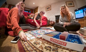 A mother and her two daughters play Monopoly at Christmas.