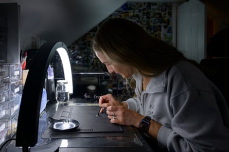 woman sits at desk and works on design under lamp