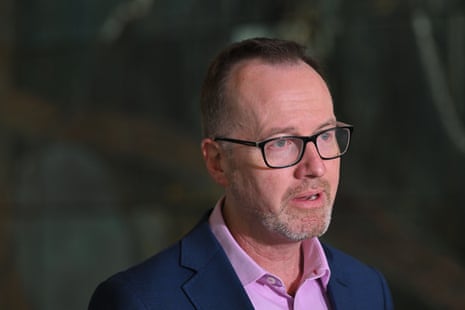 A man in glasses and a pink shirt.