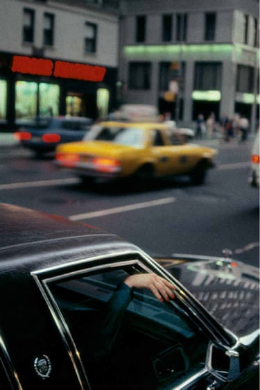 Manhattan, 1985 - a hand draped out of a car window, blurred traffic including a yellow taxi cab visible in the background