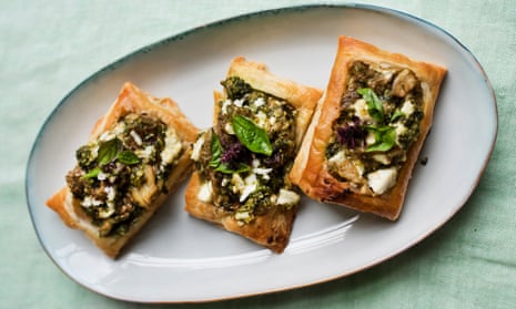 Three rectangular aubergine, basil and feta tarts lined up at an angle on an oval plate