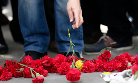 People place flowers on the ground to commemorate the victims of a bombing in Ankara, October 2015