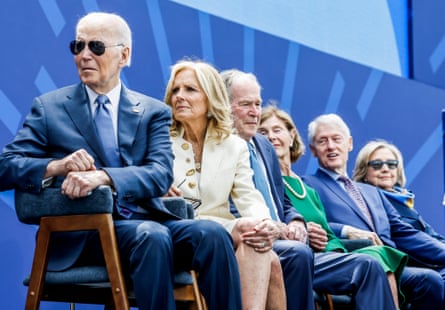 People sitting in a row on chairs on a stage.